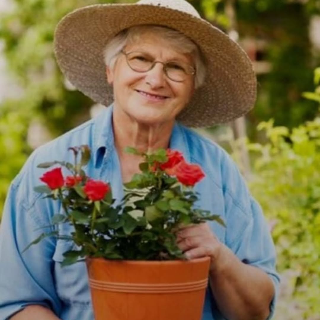 Senhora feliz cuidando de flores no jardim